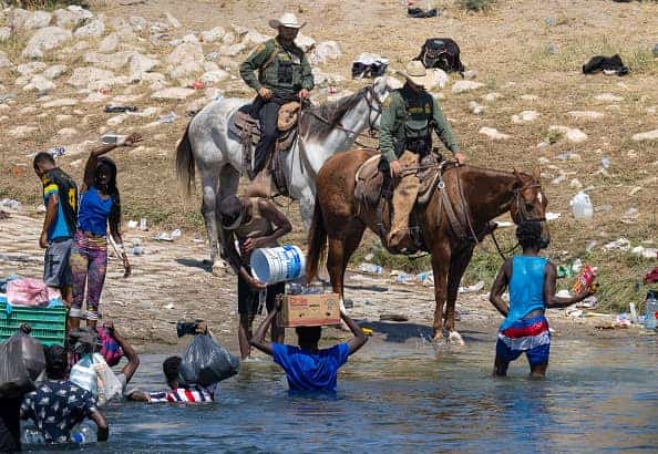 20: U.S. Border Patrol agents interact with Haitian immigrants on the bank of the Rio Grande in Del Rio