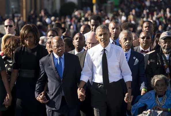 US President Barack Obama walks alongside Amelia Boynton Robinson (R)
