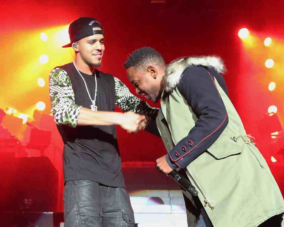 J.cole and Kendrick Lamar embracing each other on stage