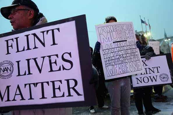 Demonstrators demand action from the Republican presidential candidates about the water crisis in Flint outside the historic Fox