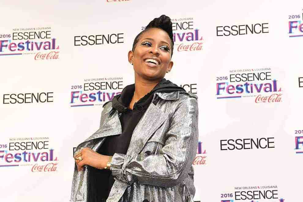 Dej Loaf smiling and wearing a silver jacket