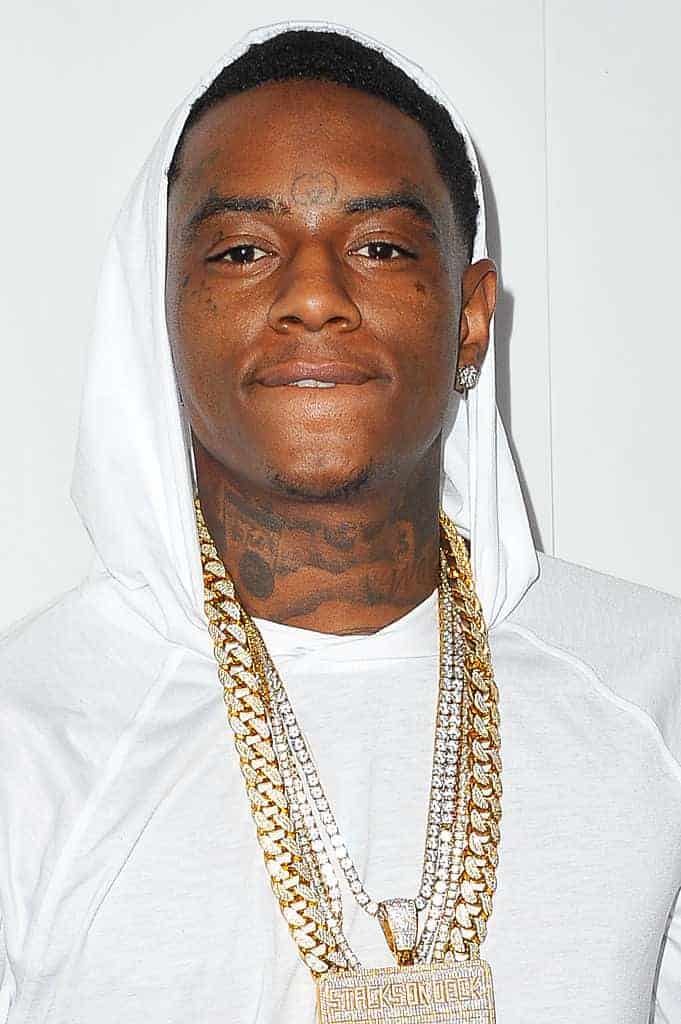 A Close up of Soulja Boy wearing a white hoodie and gold chains