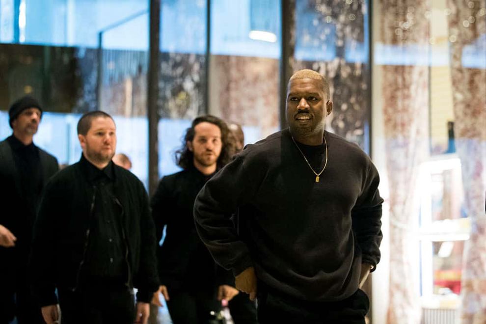 Kanye West wearing a black shirt and jeans