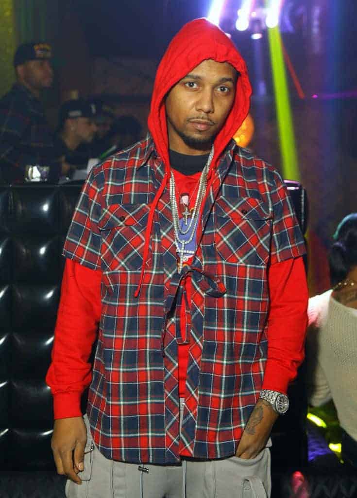 Juelz Santana wearing a red shirt with a red and blue plaid shirt over it.