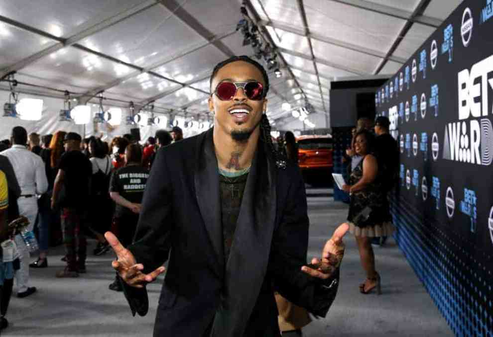 August Alsina wearing all black with black shades on