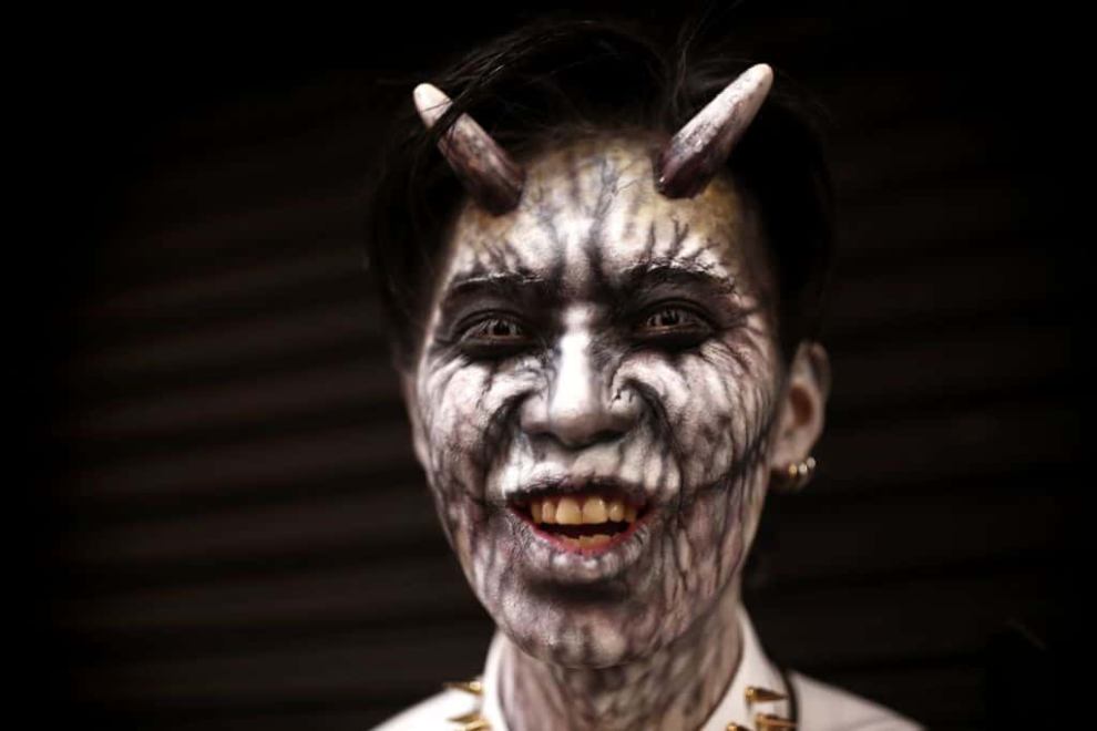 A man with a Halloween makeup poses in a street during a Halloween parade in Tokyo