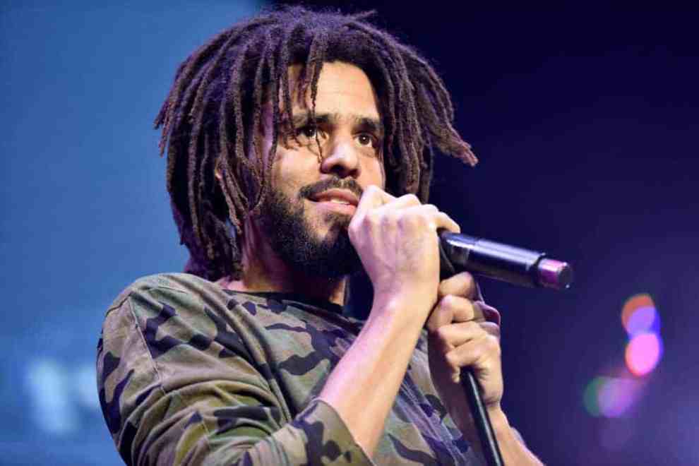 J.Cole standing in front of the microphone