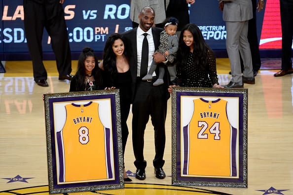 Kobe Bryant poses with his family at halftime after both his #8 and #24 Los Angeles Lakers jerseys are retired at Staples Center on December 18
