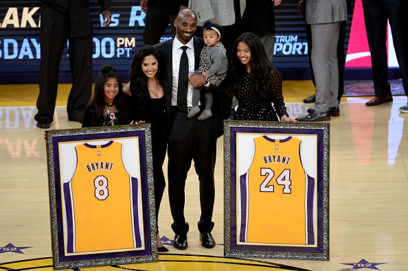 Kobe Bryant poses with his family at halftime after both his #8 and #24 Los Angeles Lakers jerseys are retired at Staples Center on December 18