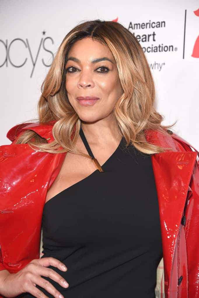 Wendy Williams wearing a black dress and a red jacket