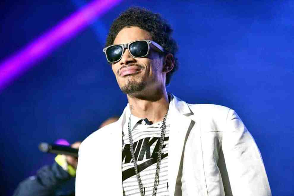 Layzie Bone wearing all white and black sunglasses on stages