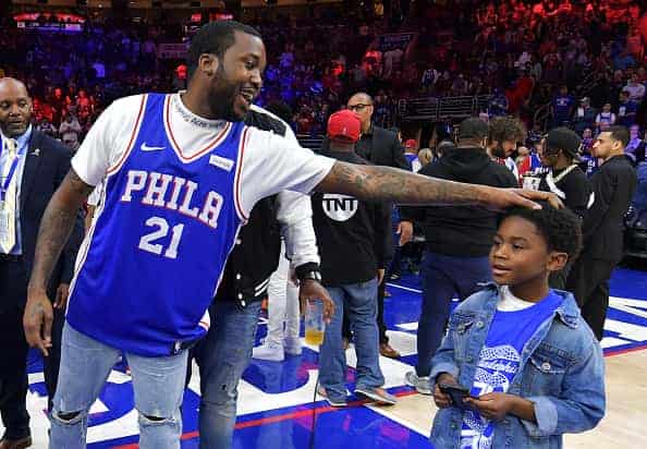 Entertainer Meek Mill stands with his son Papi at halftime during the game between the Miami Heat and Philadelphia 76ers at Wells Fargo Center on April 24