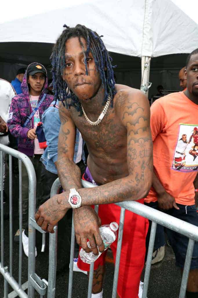 Famous Dex leaning on the gate shirtless