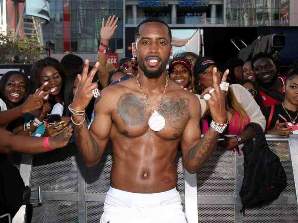 Safaree without shirt on giving peace signs with both hands