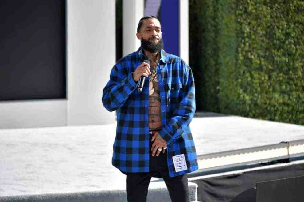 Nipsey Hussle wearing a blue and black checkered shirt