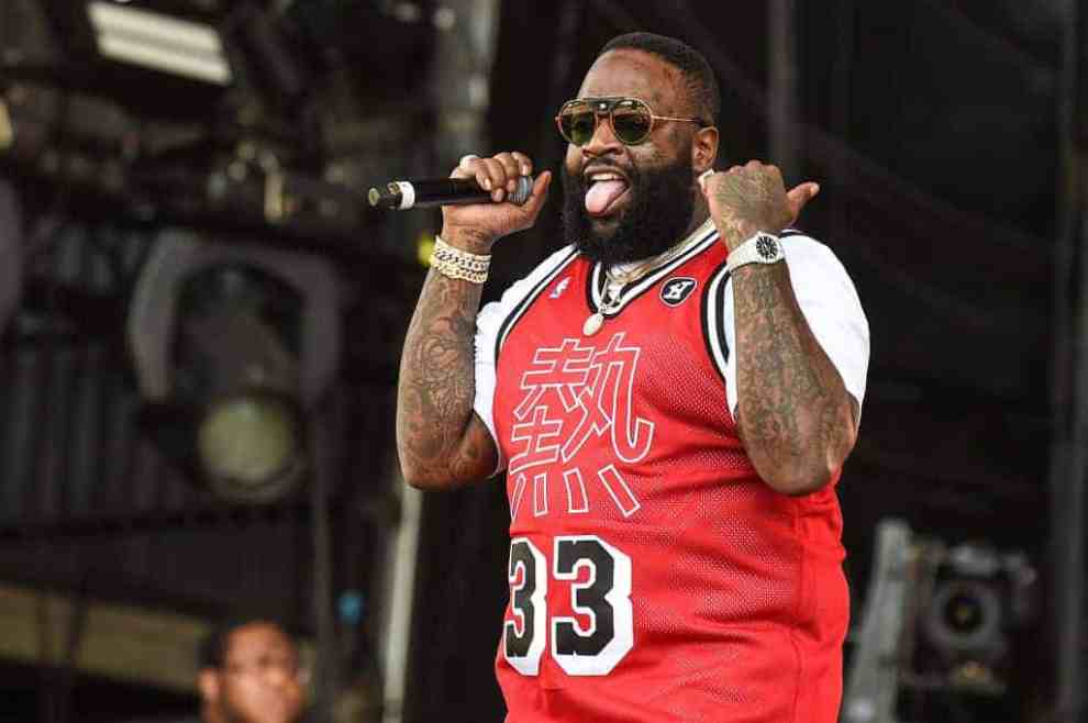 Rick Ross wearing a red jersey sticking his tongue out