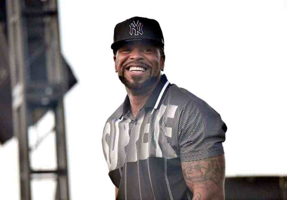 Method Man smiling on stage wearing a black cap