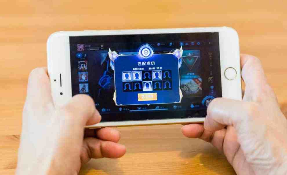 A teenager playing on a cell phone playing a game.