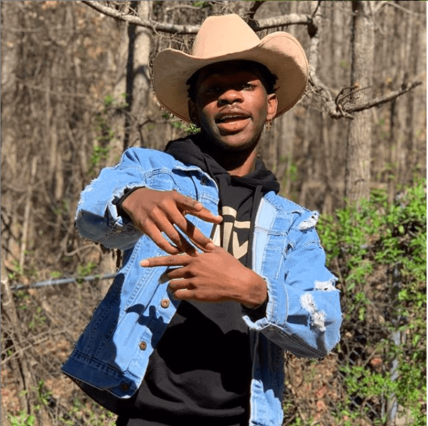 Lil Nas x wearing cowboy hat and blue jean jacket