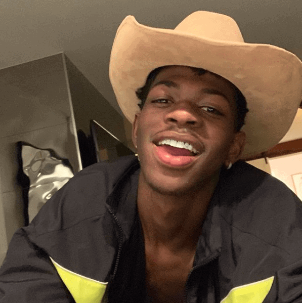 Lil Nas X wearing a cowboy hat and black and yellow jacket