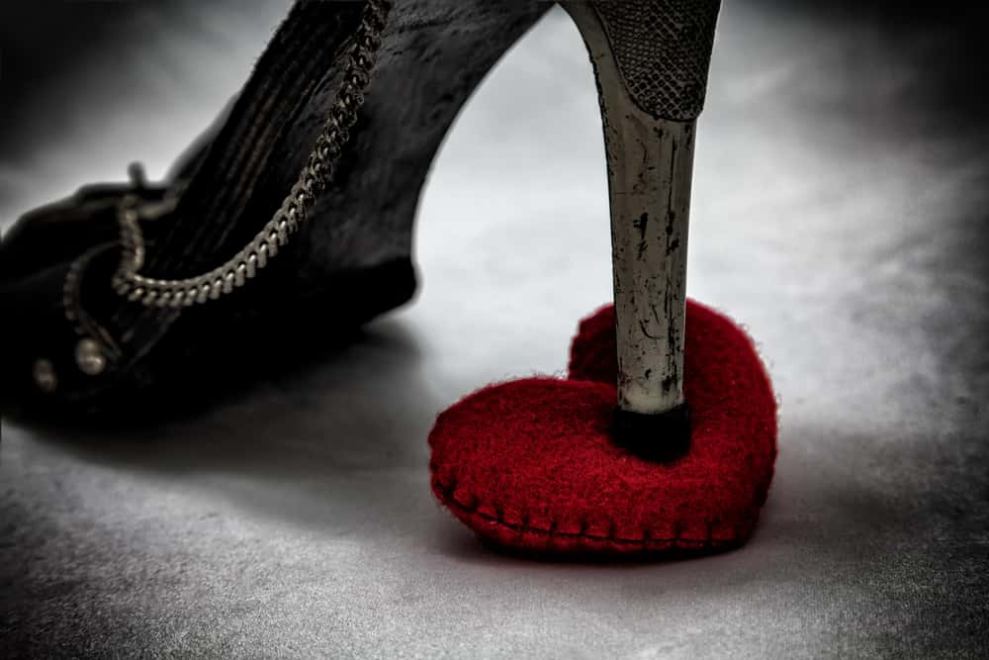 A black heel stepping on a red heart.