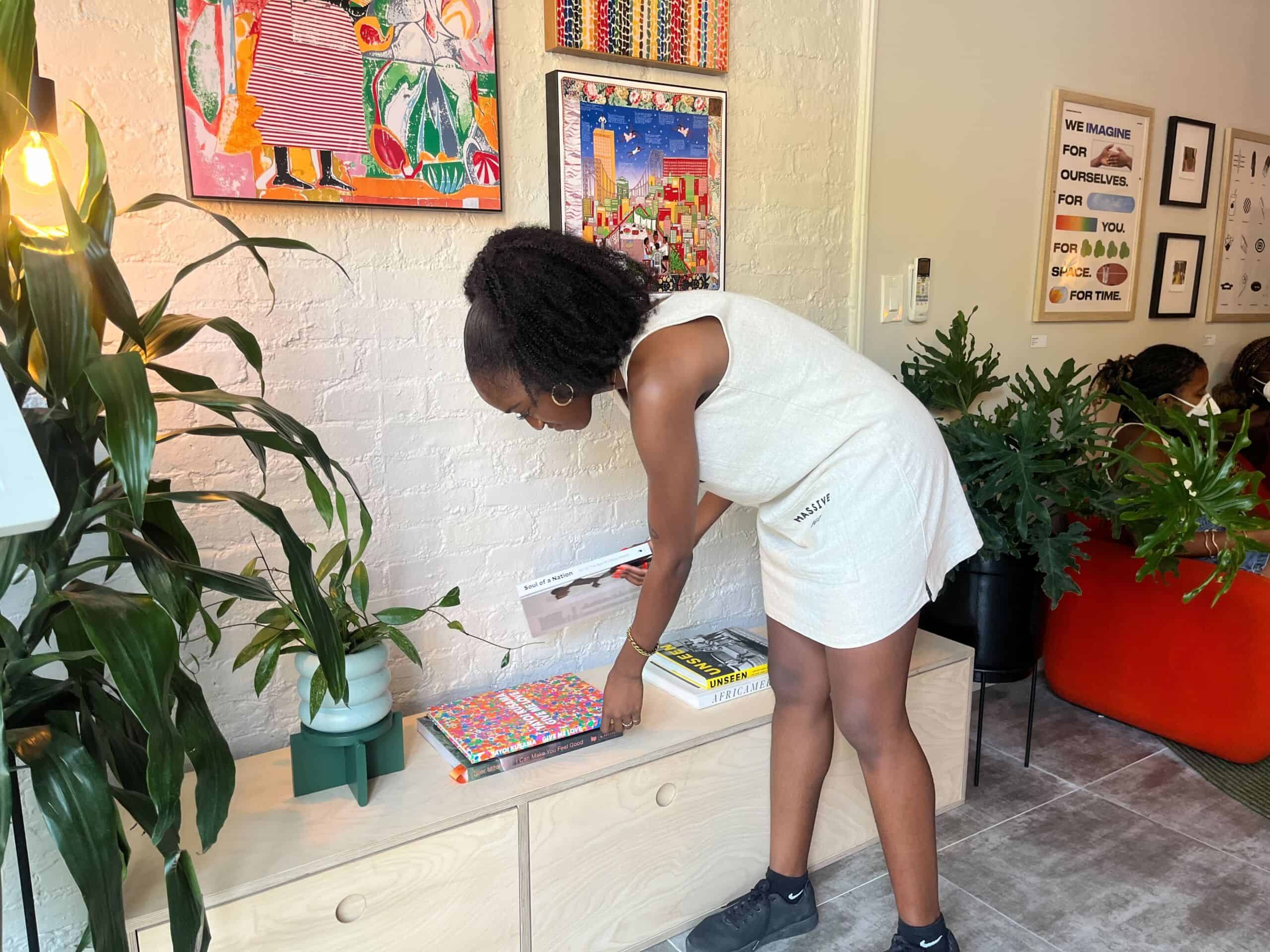Naj Austin organizes books at the Somewhere Good co-working space in Bedstuy Brooklyn