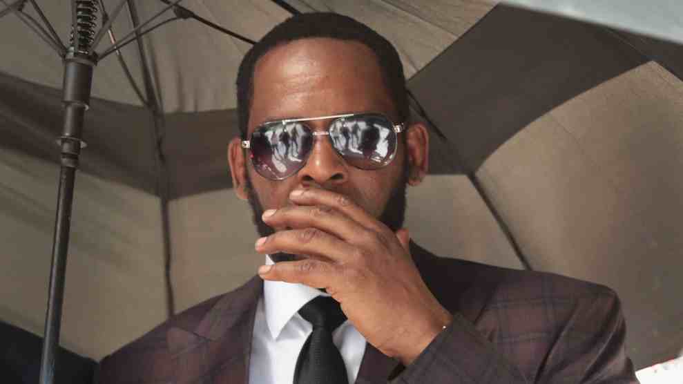 CHICAGO, ILLINOIS - JUNE 26: R&B singer R. Kelly covers his mouth as he speaks to members of his entourage as he leaves the Leighton Criminal Courts Building following a hearing on June 26, 2019 in Chicago, Illinois. Prosecutors turned over to Kelly's defense team a DVD that alleges to show Kelly having sex with an underage girl in the 1990s. Kelly has been charged with multiple sex crimes involving four women, three of whom were underage at the time of the alleged encounters.