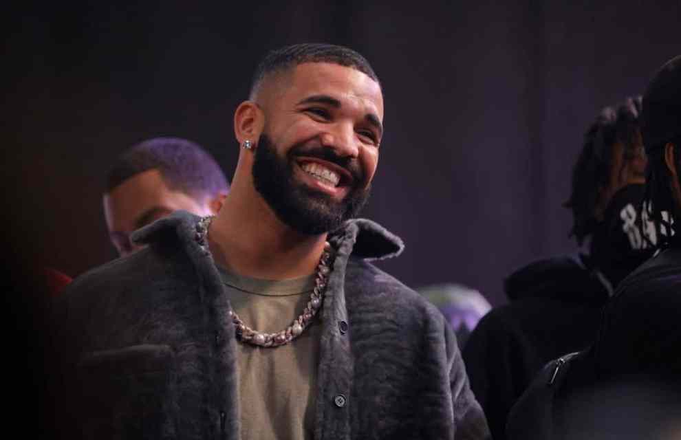 Drake smiling widely at his 2022 battle rap event.