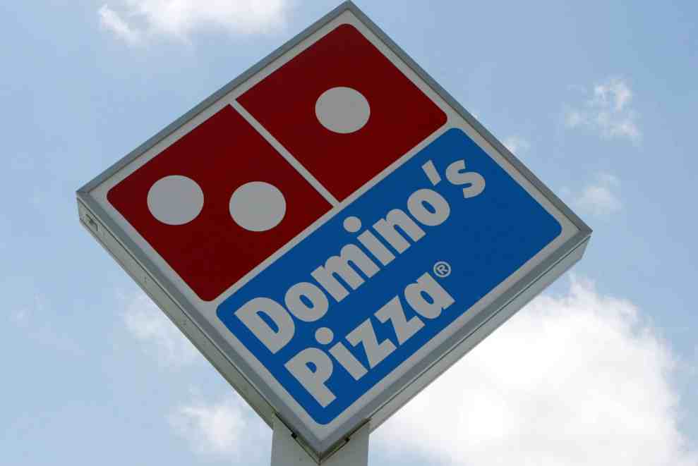 MIAMI, FL - APRIL 14: A sign in front of a Domino's Pizza April 14, 2004 in Miami, Florida. Domino's Pizza is looking to raise $300 million in the stock market by listing on the New York Stock exchange. The Michigan-based firm already has a London stock market listing for its UK subsidiary. According to media reports, the funds raised may be used to pay off debts. The 44-year-old firm now has 7,400 outlets in more than 50 countries. The firm is reporting that pizza sales are up 5.8% in 2003.