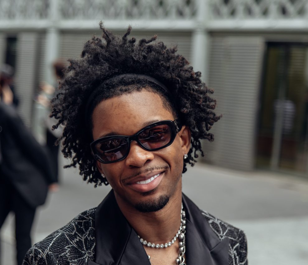 PARIS, FRANCE - JUNE 26: d4vd is wearing a tailored blazer adorned with intricate silver floral embroidery paired with striking silver jewelry, black sunglasses, and carefully styled curly hair. Seen during AMIRI the Menswear Spring/Summer 2026 show as part of Paris Fashion Week on June 26, 2025, in Paris, France.