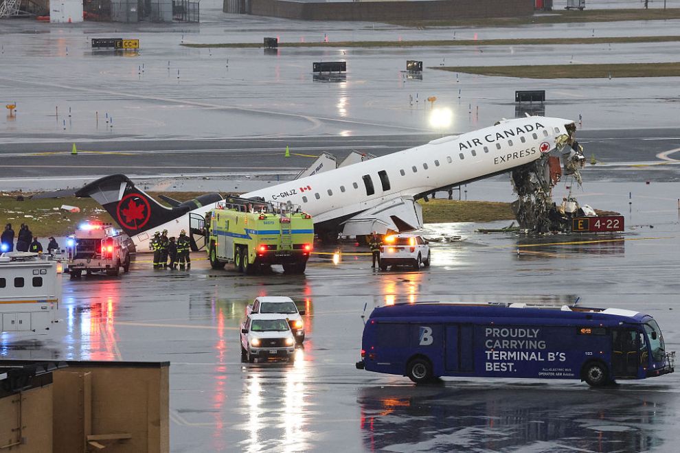 TOPSHOT - An Air Canada Express CRJ-900 sits on the runway after colliding with a Port Authority fire truck at LaGuardia Airport in New York, on March 23, 2026. A plane carrying dozens of people collided with a fire truck on a runway at New York's LaGuardia airport, killing the pilot and co-pilot and causing "serious injuries" to others, authorities said Monday. Due to the crash late Sunday, US aviation authorities halted all flights at LaGuardia, and the port authority said the airport would stay shut until at least 2:00 pm (1800 GMT) "to allow for a thorough investigation."